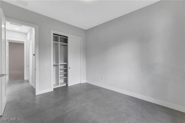3366 72nd Ave NE, Naples, FL 34120 - unfurnished bedroom featuring baseboards, concrete floors, and a closet