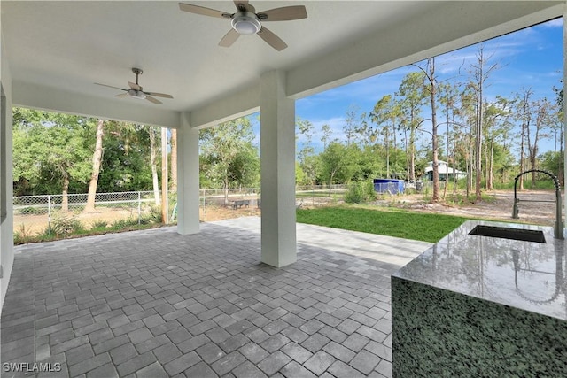3366 72nd Ave NE, Naples, FL 34120 - view of patio / terrace featuring a sink, ceiling fan, and view of wooded area