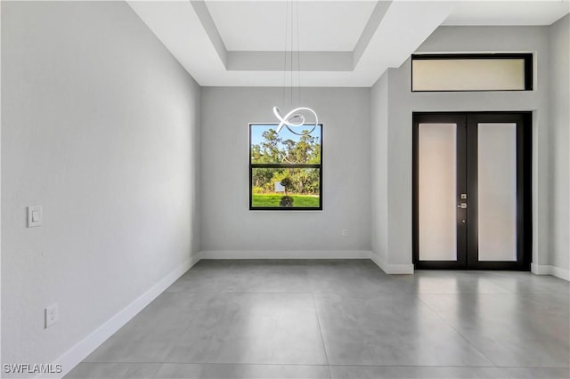3366 72nd Ave NE, Naples, FL 34120 - spare room featuring a chandelier, french doors, a tray ceiling, and baseboards