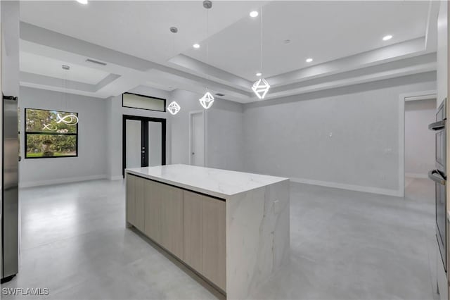 3366 72nd Ave NE, Naples, FL 34120 - kitchen with a raised ceiling, modern cabinets, open floor plan, a kitchen island, and light stone countertops