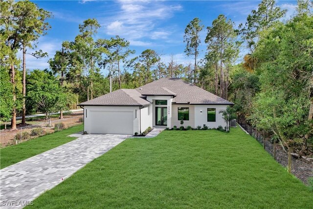 3366 72nd Ave NE, Naples, FL 34120 - view of front of property with french doors, a garage, a front lawn, roof with shingles, and stucco siding