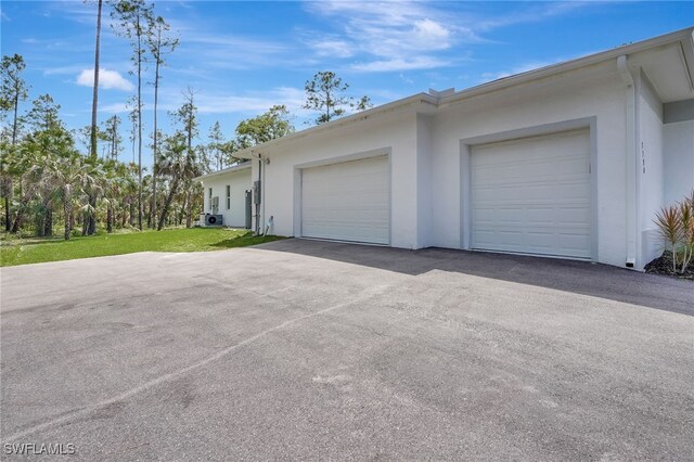 3390 12th Ave SE, Naples, FL 34117 - view of home's exterior with stucco siding, an attached garage, and driveway