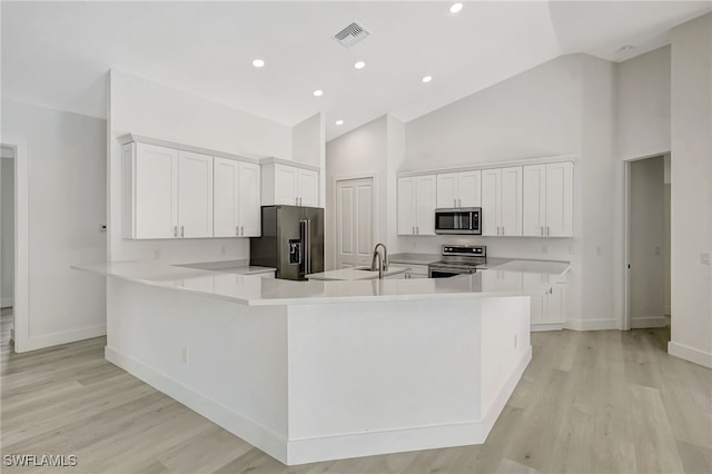 3390 12th Ave SE, Naples, FL 34117 - kitchen featuring stainless steel appliances, baseboards, high vaulted ceiling, white cabinetry, and light wood-type flooring