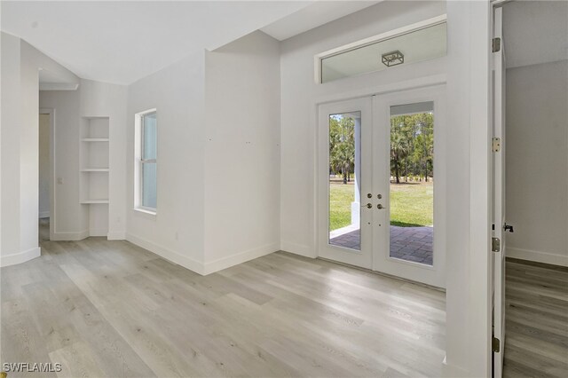 3390 12th Ave SE, Naples, FL 34117 - doorway with french doors, wood finished floors, and baseboards