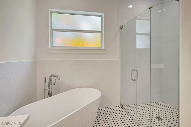 3390 12th Ave SE, Naples, FL 34117 - bathroom featuring tile walls, a stall shower, and a freestanding bath