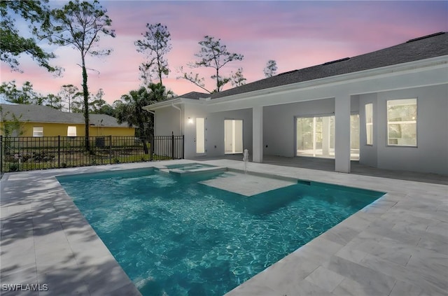 3390 12th Ave SE, Naples, FL 34117 - pool at dusk featuring a patio, fence, and a pool with connected hot tub