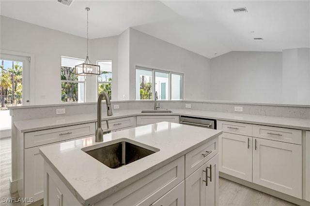 3390 12th Ave SE, Naples, FL 34117 - kitchen with a sink, a kitchen island with sink, white cabinetry, and vaulted ceiling