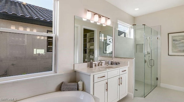 bathroom with a stall shower, vanity, and a tub