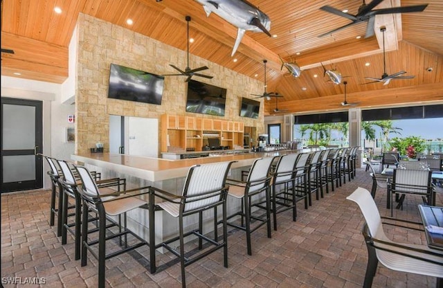 kitchen with wood ceiling, a ceiling fan, high vaulted ceiling, beam ceiling, and brick floors