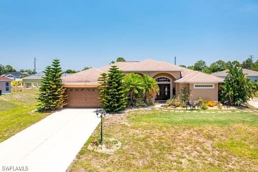914 Albert Ave, Lehigh Acres, FL 33971 - ranch-style home featuring driveway, an attached garage, and a front lawn
