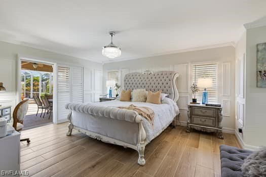 914 Albert Ave, Lehigh Acres, FL 33971 - bedroom with access to exterior, wood finished floors, a decorative wall, and crown molding