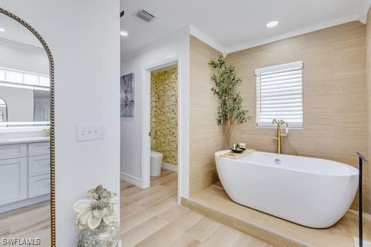 914 Albert Ave, Lehigh Acres, FL 33971 - bathroom featuring vanity, a freestanding bath, ornamental molding, recessed lighting, and wood finished floors