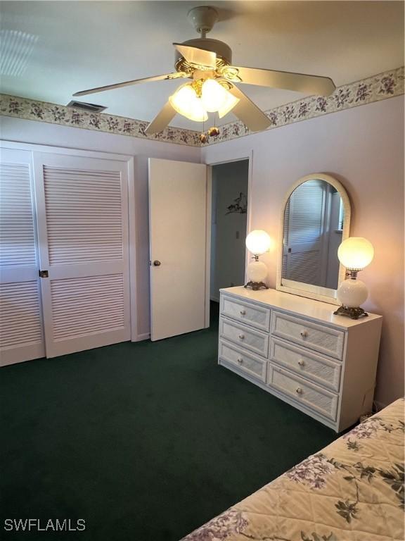 7731 Bocilla Ln Unit 9, Bokeelia, FL 33922 - bedroom featuring dark colored carpet, a ceiling fan, and a closet
