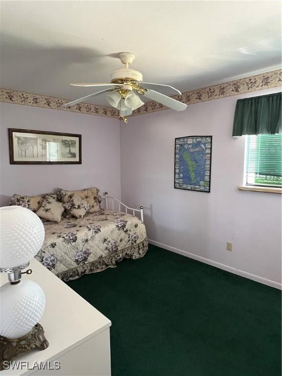 7731 Bocilla Ln Unit 9, Bokeelia, FL 33922 - bedroom with dark colored carpet, baseboards, and a ceiling fan