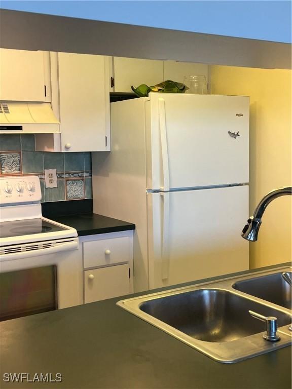 7731 Bocilla Ln Unit 9, Bokeelia, FL 33922 - kitchen with white appliances, ventilation hood, a sink, white cabinets, and dark countertops