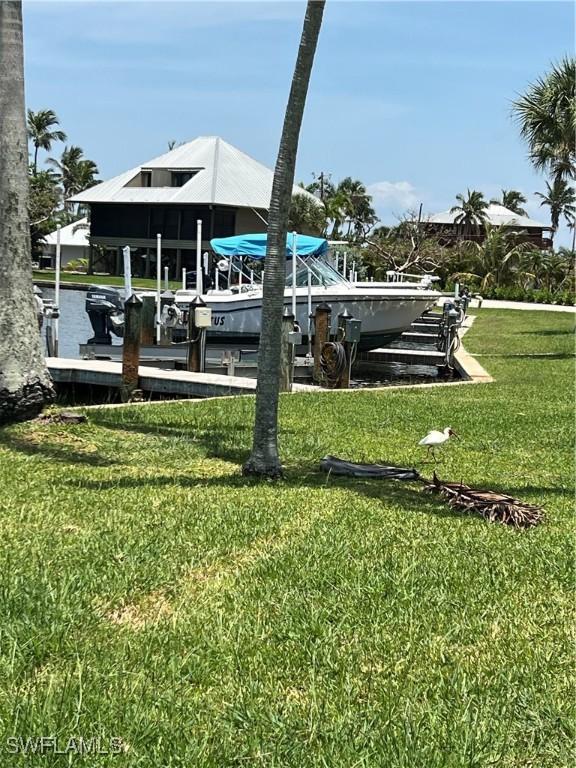 7731 Bocilla Ln Unit 9, Bokeelia, FL 33922 - dock featuring boat lift and a yard