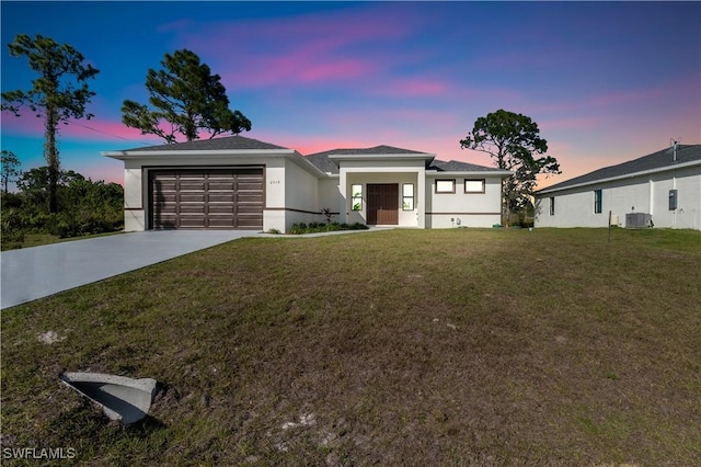 3604 Flora Ave N, Lehigh Acres, FL 33971 - view of front facade with a garage, cooling unit, driveway, a front yard, and stucco siding