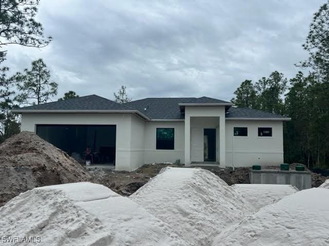 3107 33rd St W, Lehigh Acres, FL 33971 - prairie-style house with a garage, stucco siding, and a shingled roof