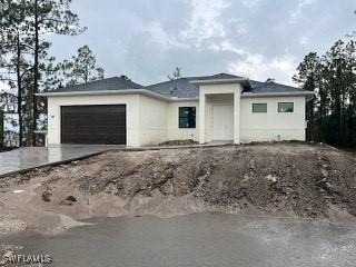 3107 33rd St W, Lehigh Acres, FL 33971 - prairie-style house with an attached garage, driveway, and stucco siding
