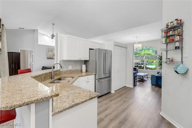 120 Heritage Way, Naples, FL 34110 - kitchen with a sink, high end refrigerator, a peninsula, white cabinets, and light stone countertops