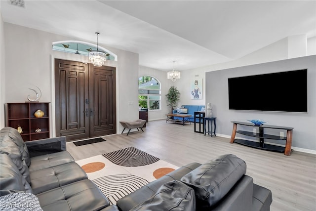 120 Heritage Way, Naples, FL 34110 - living room featuring a chandelier, light wood finished floors, and baseboards
