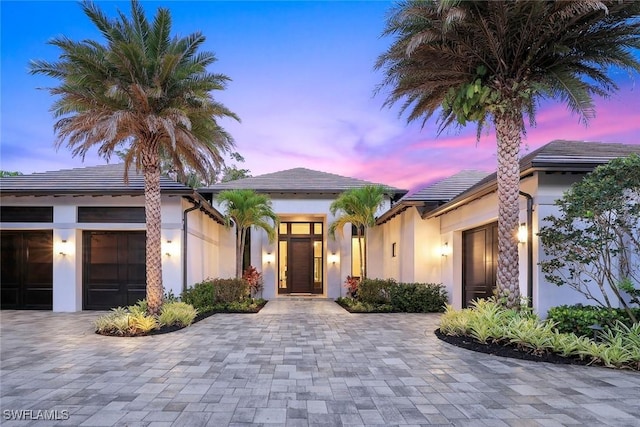 541 Whispering Pine Ct, Naples, FL 34103 - view of front of house with stucco siding, a garage, decorative driveway, and a tile roof