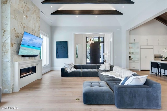 541 Whispering Pine Ct, Naples, FL 34103 - living area featuring beam ceiling, light wood-style flooring, and a glass covered fireplace