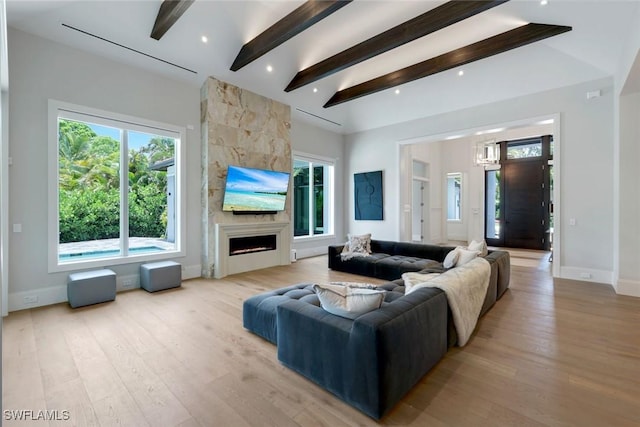 541 Whispering Pine Ct, Naples, FL 34103 - living area with beam ceiling, light wood-type flooring, a large fireplace, baseboards, and a chandelier
