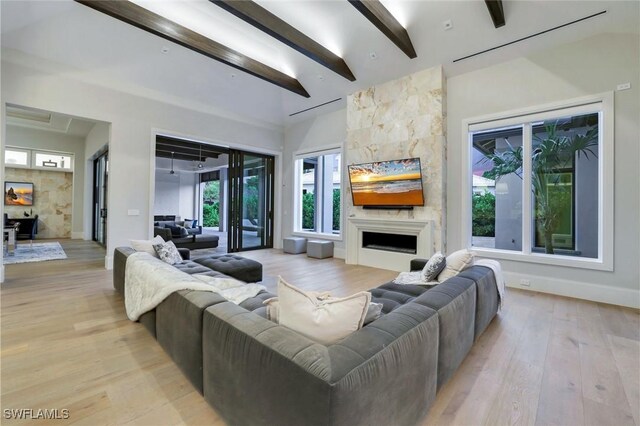 541 Whispering Pine Ct, Naples, FL 34103 - living room featuring a large fireplace, beam ceiling, light wood-type flooring, and baseboards
