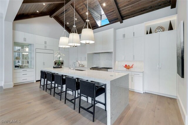 541 Whispering Pine Ct, Naples, FL 34103 - kitchen with wooden ceiling with exposed beams, high vaulted ceiling, light wood-type flooring, a kitchen breakfast bar, and decorative light fixtures