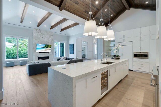 541 Whispering Pine Ct, Naples, FL 34103 - kitchen featuring a sink, beverage cooler, modern cabinets, light wood-type flooring, and high vaulted ceiling