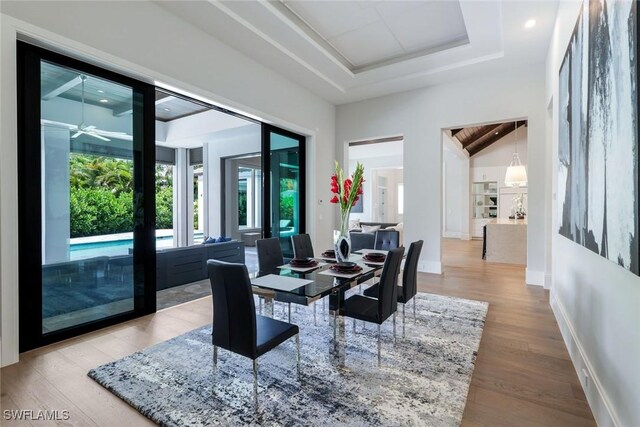 541 Whispering Pine Ct, Naples, FL 34103 - dining area featuring wood finished floors, baseboards, a tray ceiling, and ceiling fan