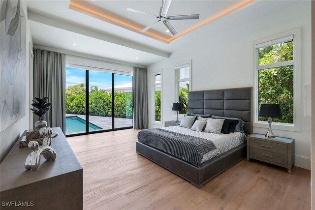 541 Whispering Pine Ct, Naples, FL 34103 - bedroom featuring access to exterior, a tray ceiling, wood finished floors, recessed lighting, and ceiling fan
