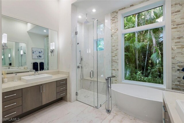 541 Whispering Pine Ct, Naples, FL 34103 - bathroom featuring vanity, a shower stall, a freestanding bath, and marble finish flooring