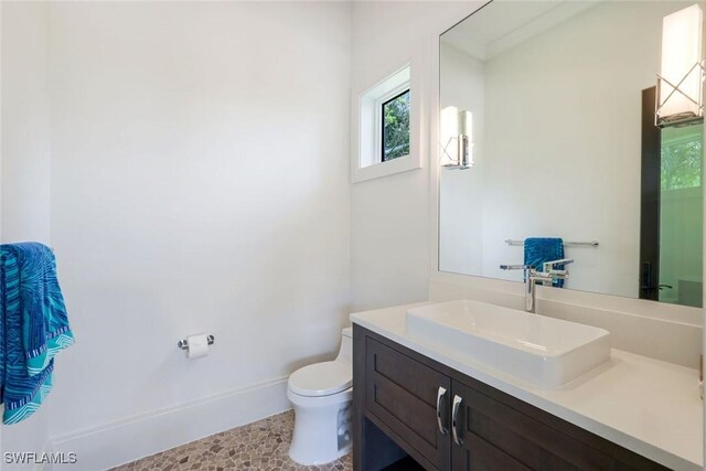 541 Whispering Pine Ct, Naples, FL 34103 - bathroom with plenty of natural light, toilet, vanity, and baseboards