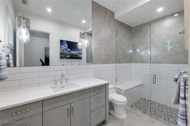 541 Whispering Pine Ct, Naples, FL 34103 - full bath with vanity, a shower stall, toilet, tile walls, and backsplash