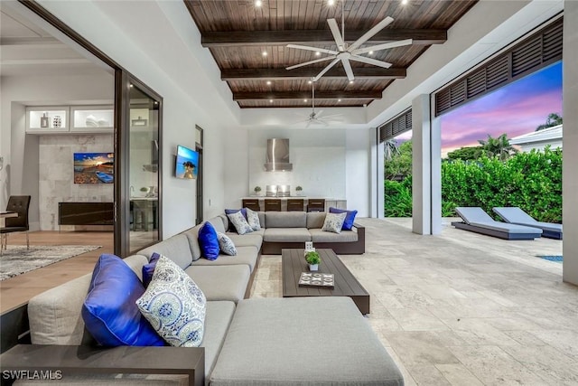541 Whispering Pine Ct, Naples, FL 34103 - living room featuring wood ceiling with exposed beams, ceiling fan, stone finish floors, and a high ceiling