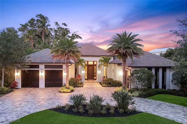 541 Whispering Pine Ct, Naples, FL 34103 - view of front of house with an attached garage, decorative driveway, and stucco siding