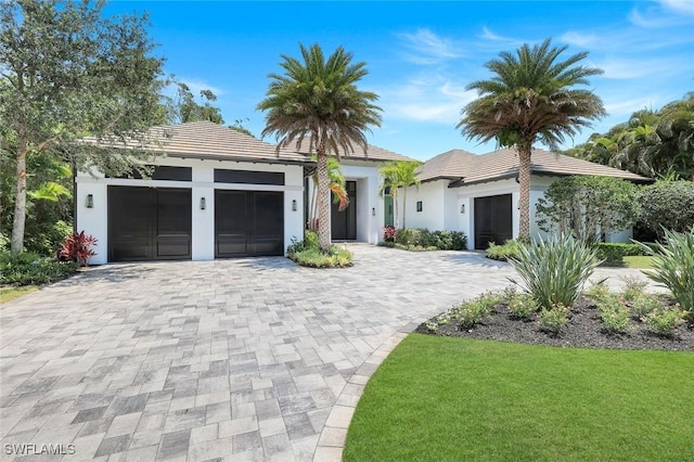541 Whispering Pine Ct, Naples, FL 34103 - view of front of house with a tiled roof, stucco siding, an attached garage, and decorative driveway