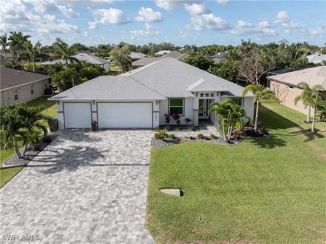 1806 SW 17th St, Cape Coral, FL 33991 - view of front of house featuring an attached garage, decorative driveway, a front lawn, a shingled roof, and stucco siding