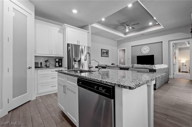 1806 SW 17th St, Cape Coral, FL 33991 - kitchen featuring appliances with stainless steel finishes, ceiling fan, an island with sink, dark wood finished floors, and light stone counters