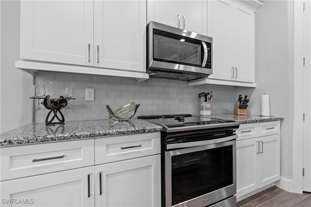 1806 SW 17th St, Cape Coral, FL 33991 - kitchen with stainless steel appliances, decorative backsplash, light stone countertops, white cabinetry, and wood finished floors