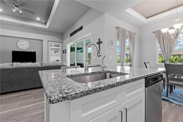 1806 SW 17th St, Cape Coral, FL 33991 - kitchen featuring a tray ceiling, a sink, light wood-type flooring, light stone counters, and a chandelier