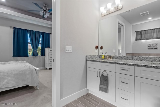 1806 SW 17th St, Cape Coral, FL 33991 - ensuite bathroom with baseboards, ceiling fan, double vanity, and wood finished floors