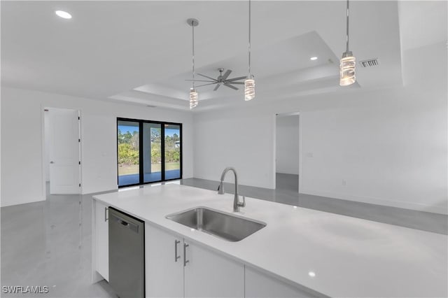 kitchen featuring dishwasher, a sink, a tray ceiling, open floor plan, and light countertops