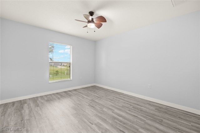 unfurnished room featuring wood finished floors, ceiling fan, and baseboards