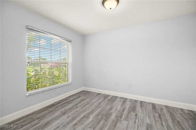 spare room with wood finished floors and baseboards
