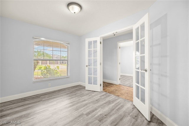 unfurnished room with french doors, wood finished floors, and baseboards