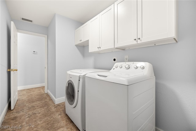 laundry area with cabinet space, washer and dryer, baseboards, and stone finish flooring