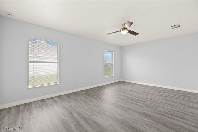 unfurnished room with wood finished floors, ceiling fan, baseboards, and a smoke detector